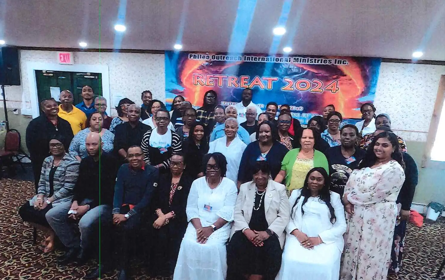 A large group of people posing indoors at an event.