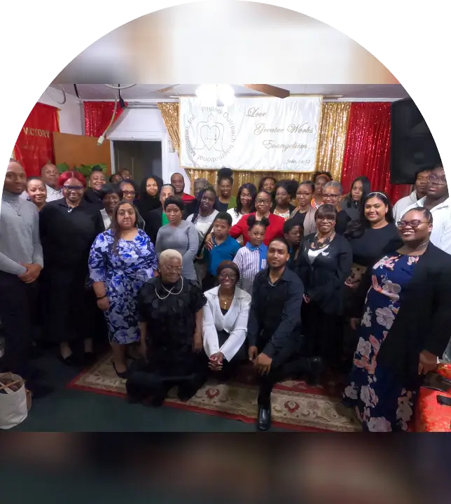 Large group posing inside a decorated room for a formal photo.
