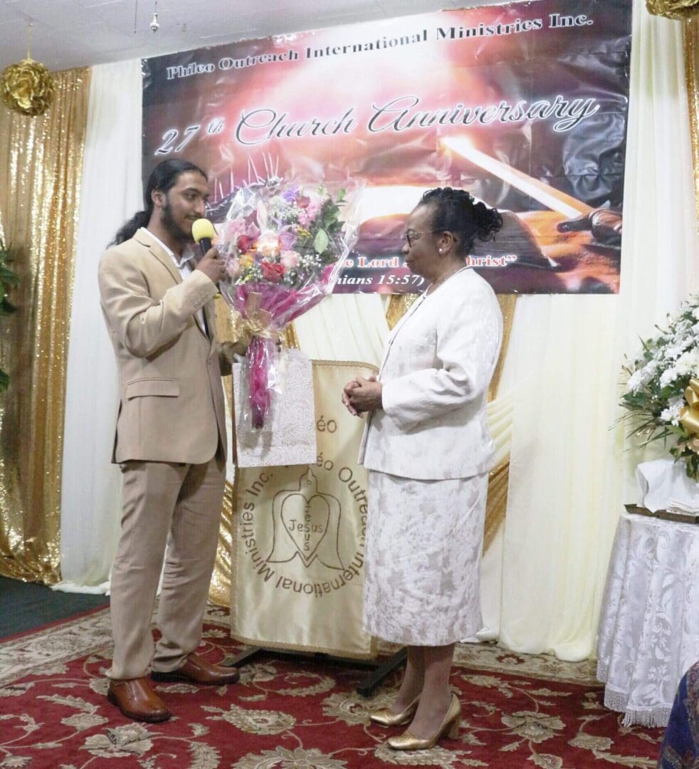 A man and a woman exchanging flowers during a formal event.