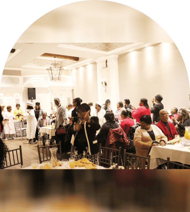 A busy indoor event with many people socializing and seated.